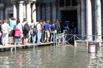 Over de loopbrug naar Basilica San Marco bij acqua alta. Zo houd je je voeten droog.